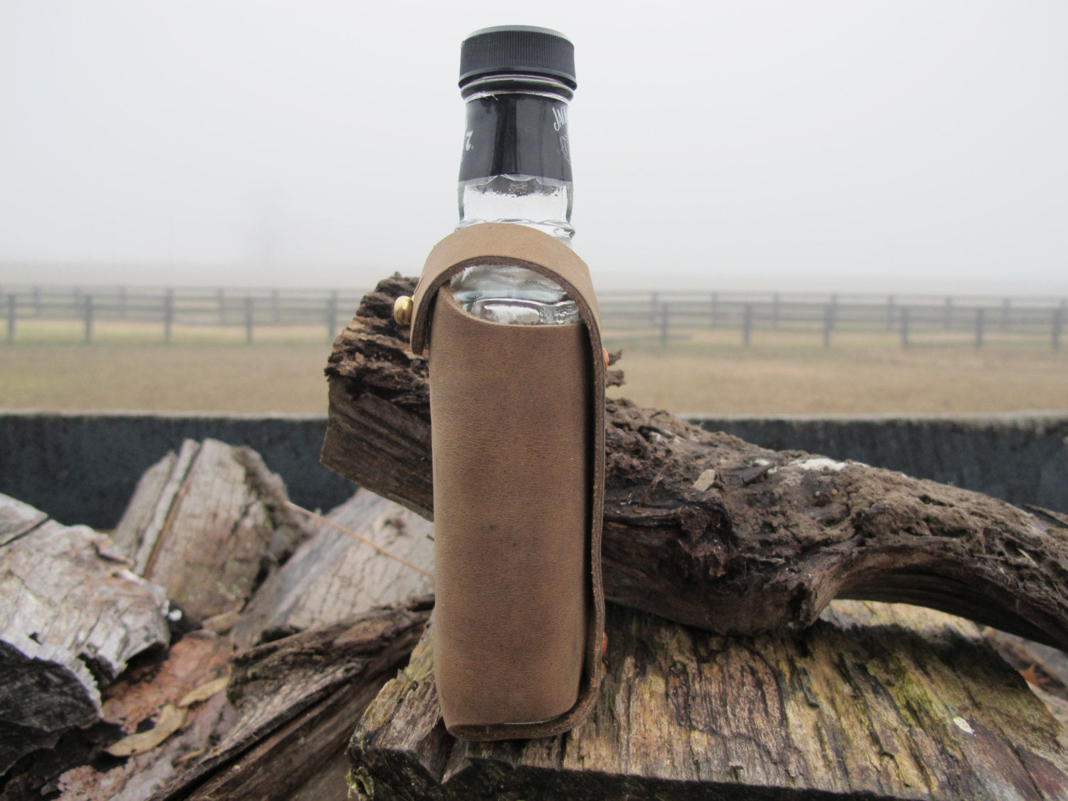 Leather water bottle holder with strap and glass bottle